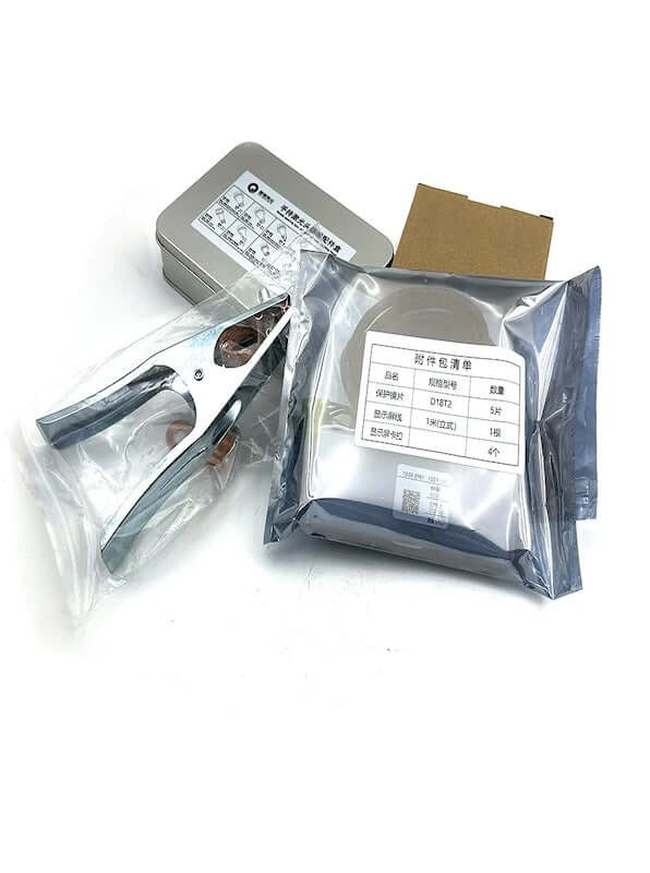 Welding system components and accessories in packaging, including clamping tool and labeled boxes.
